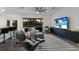 Open-concept living room with sleek furniture, a large TV, and an adjacent kitchen area at 9408 Glen Abbey Ln, Sarasota, FL 34238