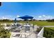 This outdoor seating area overlooks the well manicured community golf course with an umbrella for shade at 9408 Glen Abbey Ln, Sarasota, FL 34238