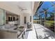 Covered patio with ample seating, fan, and views of the pool and golf course at 9408 Glen Abbey Ln, Sarasota, FL 34238