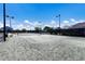 Outdoor tennis court surrounded by a black fence and lush greenery on a sunny day at 9408 Glen Abbey Ln, Sarasota, FL 34238