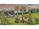 An expansive backyard showcases a screened lanai, green lawn, and tropical plants for serene outdoor living at 9928 Bright Water Dr, Englewood, FL 34223
