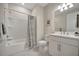 Clean, white bathroom featuring a shower-tub combo, white vanity, and neutral accents for a relaxing atmosphere at 9928 Bright Water Dr, Englewood, FL 34223