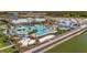 Aerial view of a luxurious community pool with beach volleyball, ample seating, and mature palm trees at 9928 Bright Water Dr, Englewood, FL 34223
