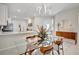 Bright, airy dining area with a glass table, modern chandelier, and view into the kitchen at 9928 Bright Water Dr, Englewood, FL 34223