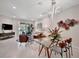 Bright, open-concept living area features modern lighting, a glass dining table, and sliding door access to outdoor space at 9928 Bright Water Dr, Englewood, FL 34223