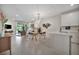 Open living space with dining area, modern chandelier, access to the outdoor patio, and stylish decor at 9928 Bright Water Dr, Englewood, FL 34223