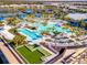 Aerial view of the beautiful community pool with lounging areas, palm trees and recreation area at 9928 Bright Water Dr, Englewood, FL 34223