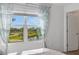 Bright bedroom featuring a large window with scenic water views and stylish curtains at 8612 Lunar Skye St, Sarasota, FL 34241