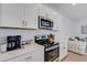 Modern kitchen featuring stainless steel appliances, quartz countertops, and stylish white cabinets at 8612 Lunar Skye St, Sarasota, FL 34241