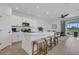 Modern kitchen featuring a large island with bar seating, stainless steel appliances, and a view of the living area at 8612 Lunar Skye St, Sarasota, FL 34241