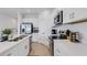 Kitchen boasting stainless steel appliances, white cabinets, quartz countertops, and tile flooring at 8612 Lunar Skye St, Sarasota, FL 34241