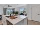Open-concept kitchen and living area with island seating and stainless steel appliances at 8612 Lunar Skye St, Sarasota, FL 34241