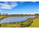 Picturesque pond view framed by lush greenery and distant houses at 8612 Lunar Skye St, Sarasota, FL 34241
