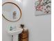 Charming powder room with a pedestal sink, floral artwork, and natural light at 8612 Lunar Skye St, Sarasota, FL 34241