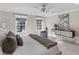 Sunlit main bedroom featuring large windows, a ceiling fan, a sitting area, and soft, neutral decor at 1011 Cimarron Nw Cir, Bradenton, FL 34209