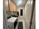 Well-organized laundry room with front loading washer and dryer, cabinets, bench, and exterior door at 10522 Green Meadow Ln, Port Richey, FL 34668