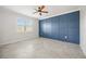 Bedroom with stylish blue accent wall, tile flooring, and natural light from large window at 11165 Balfour St, Venice, FL 34293
