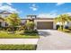 Beautiful single-story home featuring a paved driveway, lush landscaping, and a two-car garage at 11165 Balfour St, Venice, FL 34293
