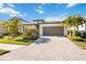 Beautiful single-story home featuring a paved driveway, lush landscaping, and a two-car garage at 11165 Balfour St, Venice, FL 34293