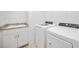 Bright laundry room featuring granite counters, white cabinets, and new washer and dryer for convenience at 11165 Balfour St, Venice, FL 34293