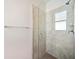 Modern tiled shower featuring a glass door, window, and sleek fixtures for a spa-like bathroom experience at 11165 Balfour St, Venice, FL 34293