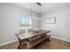 Dining area with a rustic wooden table, bench seating, and pendant lighting at 1216 Thornbury Dr, Parrish, FL 34219