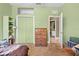 Neutral-toned bedroom featuring a closet, a dresser, and an open door to the bathroom at 13040 Quigley Ave, Weeki Wachee, FL 34614