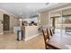 A modern kitchen featuring white cabinets, granite countertops, and stainless steel appliances open to a dining area and pool view at 13040 Quigley Ave, Weeki Wachee, FL 34614