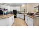 Well-equipped kitchen boasting white cabinetry, granite countertops, and black appliances providing ample space for cooking at 13040 Quigley Ave, Weeki Wachee, FL 34614