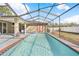 Swimming pool inside of a screened in patio with an exit to the backyard at 13040 Quigley Ave, Weeki Wachee, FL 34614