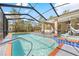Sparkling pool with a spa, surrounded by a screened enclosure offering views of the backyard at 13040 Quigley Ave, Weeki Wachee, FL 34614