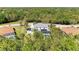 Aerial view of a home with a screened-in pool, set amidst lush greenery and mature trees, offering privacy at 14530 17Th E Ave, Bradenton, FL 34212