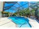 Sparkling pool and spa under a screened enclosure and tropical landscaping at 14530 17Th E Ave, Bradenton, FL 34212