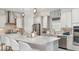 Modern kitchen with stainless steel appliances, a large island with seating, pendant lighting, and white cabinetry at 14919 Contenta Loop, Bradenton, FL 34211