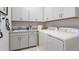 Well-lit laundry room with matching gray cabinets and countertop, plus modern washer and dryer at 14919 Contenta Loop, Bradenton, FL 34211