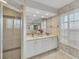 Bathroom features dual sink vanity, tiled walk-in shower, and decorative wallpaper at 1511 Waterford Dr, Venice, FL 34292