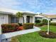 Charming single-story home with a well-manicured lawn, colorful flowers, and a beautiful walkway at 1511 Waterford Dr, Venice, FL 34292
