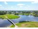 Aerial view of the golf course with a tranquil pond, lush greenery, and a scenic walking path at 1511 Waterford Dr, Venice, FL 34292