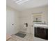 Bright laundry area featuring a utility sink, storage shelving, and a modern washer and dryer at 1511 Waterford Dr, Venice, FL 34292