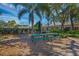 Outdoor picnic tables with umbrella near landscaped gardens, providing a relaxed and social gathering spot at 1511 Waterford Dr, Venice, FL 34292