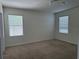 Neutral bedroom with carpet floors and natural light from two windows at 15517 Rose Grove Dr, Bradenton, FL 34212