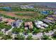 Stunning aerial view of a custom home with a beautiful tile roof, lush landscaping, and an inviting circular driveway at 16407 Daysailor Trl, Lakewood Ranch, FL 34202