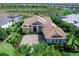 An aerial view of a sprawling one-story home surrounded by lush greenery in a serene community at 16407 Daysailor Trl, Lakewood Ranch, FL 34202