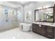 Modern bathroom featuring a soaking tub, walk-in shower with glass, and dual vanities at 16407 Daysailor Trl, Lakewood Ranch, FL 34202