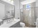 Modern bathroom features a glass shower, gray vanity with sink, and large mirror at 16407 Daysailor Trl, Lakewood Ranch, FL 34202