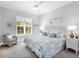Cozy bedroom with blue and white bedding, a wicker chair, and a large window at 16407 Daysailor Trl, Lakewood Ranch, FL 34202