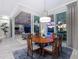 Elegant dining area with a round wooden table and sliding glass doors leading to the outdoor living space and pool at 16407 Daysailor Trl, Lakewood Ranch, FL 34202