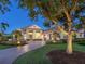 Stunning exterior view of a luxurious one-story home with lush landscaping and a paved driveway at 16407 Daysailor Trl, Lakewood Ranch, FL 34202