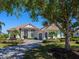 Elegant home featuring a brick driveway, lush landscaping, and a charming covered entry way with white pillars at 16407 Daysailor Trl, Lakewood Ranch, FL 34202