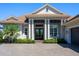 A close-up view of the home's entrance with dark double doors and decorative columns at 16407 Daysailor Trl, Lakewood Ranch, FL 34202